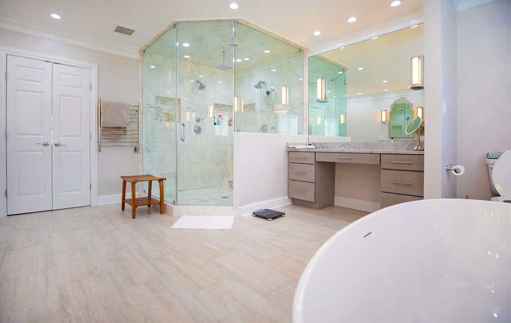 Aging in place bathroom design with a curbless glass shower, wide walkways, freestanding tub, and accessible vanity layout that supports safety, comfort, and long-term usability without sacrificing style.