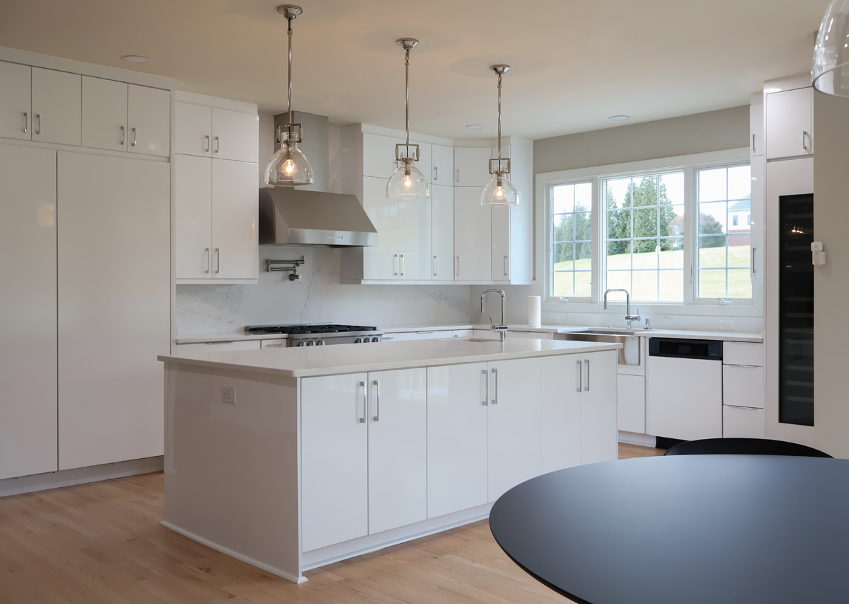 open concept kitchen remodel Alexandria VA with white cabinets large island pendant lighting and natural light