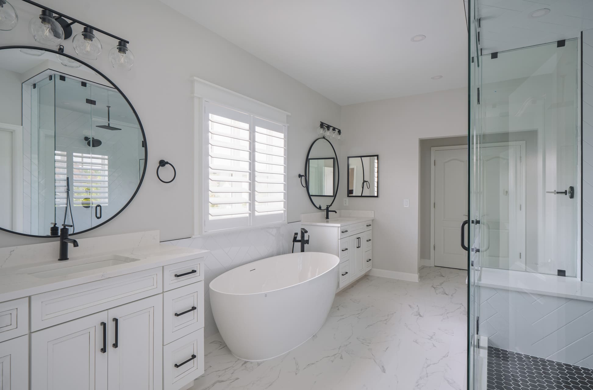 Washington DC bathroom remodel with marble look tile flooring freestanding tub glass shower and white vanity