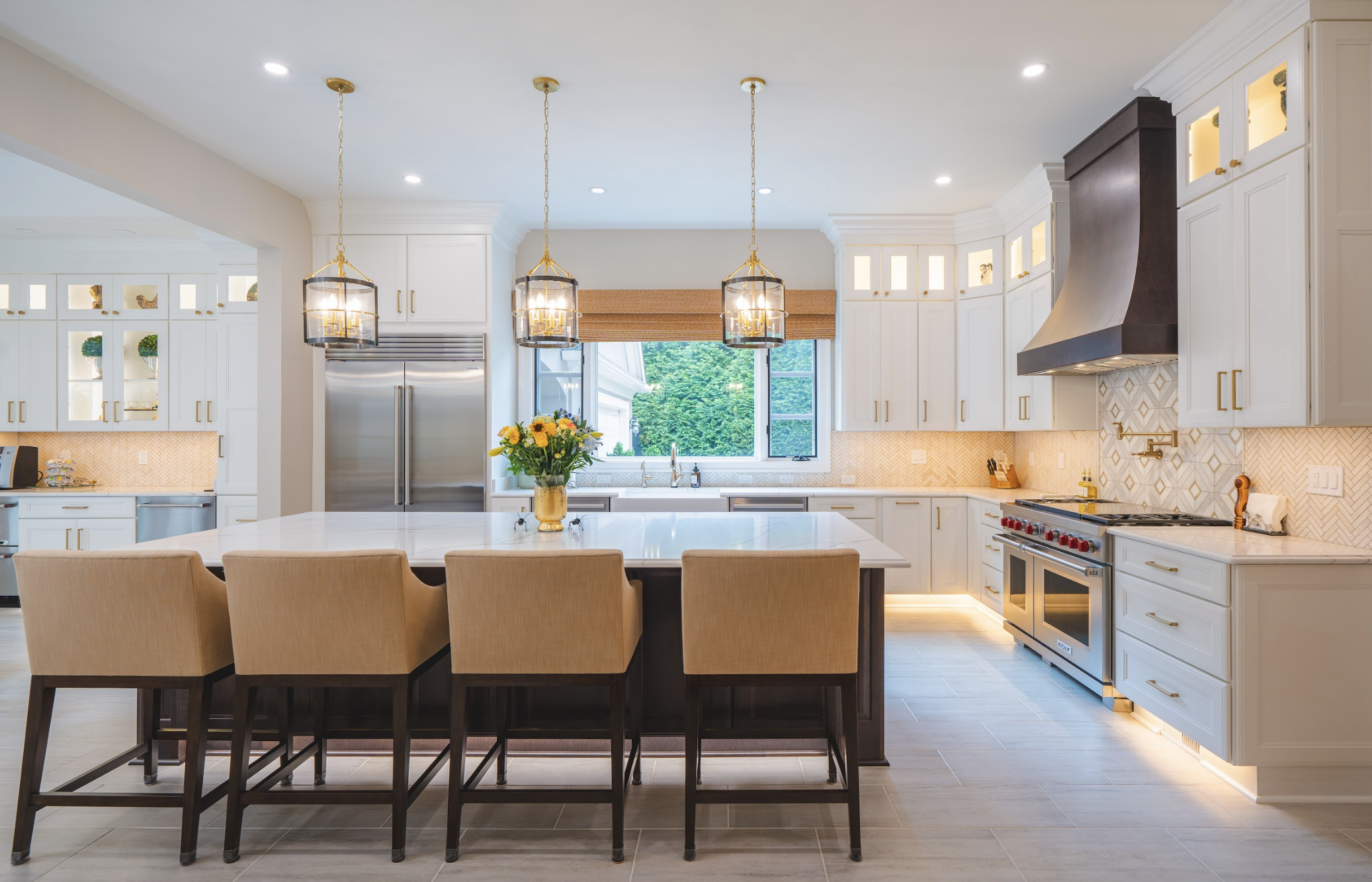 Chantilly VA luxury kitchen remodel with white shaker cabinets, large island, gold pendant lights, and herringbone backsplash