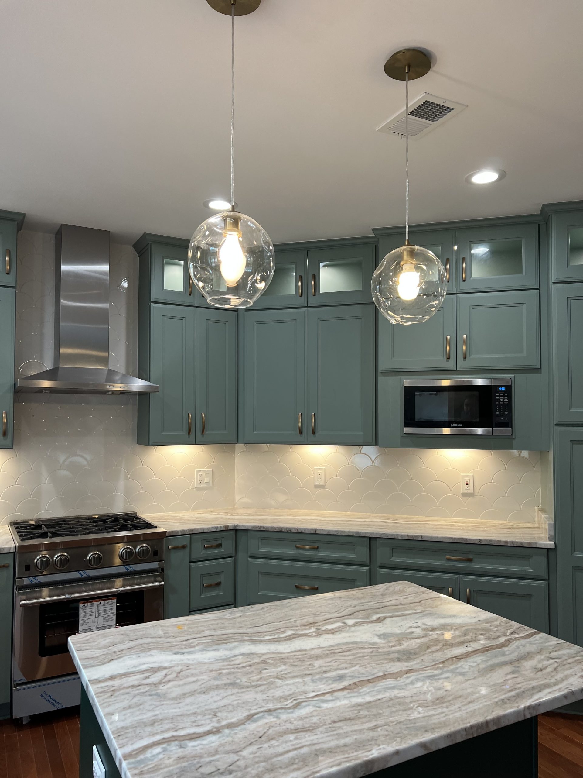 custom kitchen remodeling with new cabinets, island, and stainless steel appliances