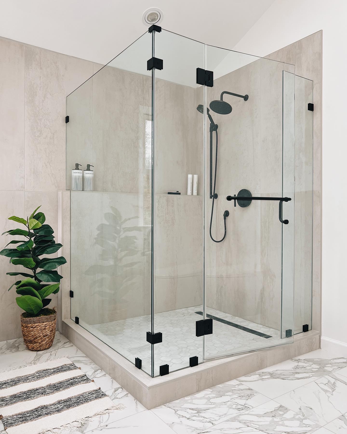 Walk-in shower with low threshold, clear glass, and modern tile
