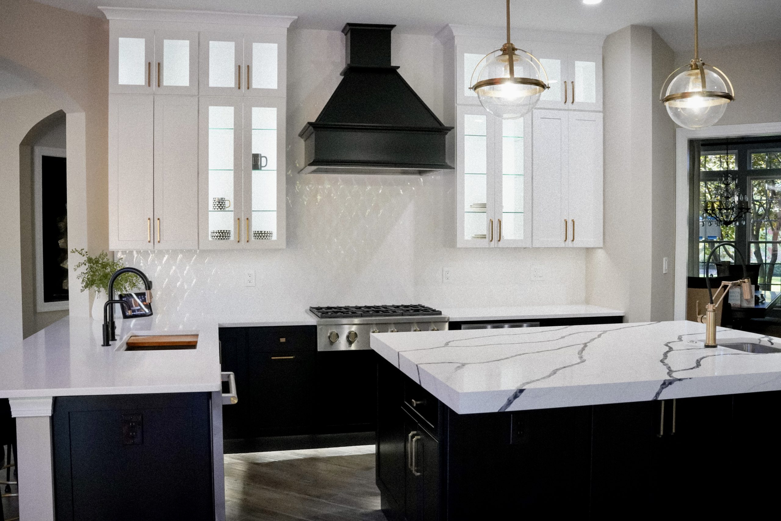 Contemporary kitchen with black cabinets and a dramatic countertop featuring bold white veining