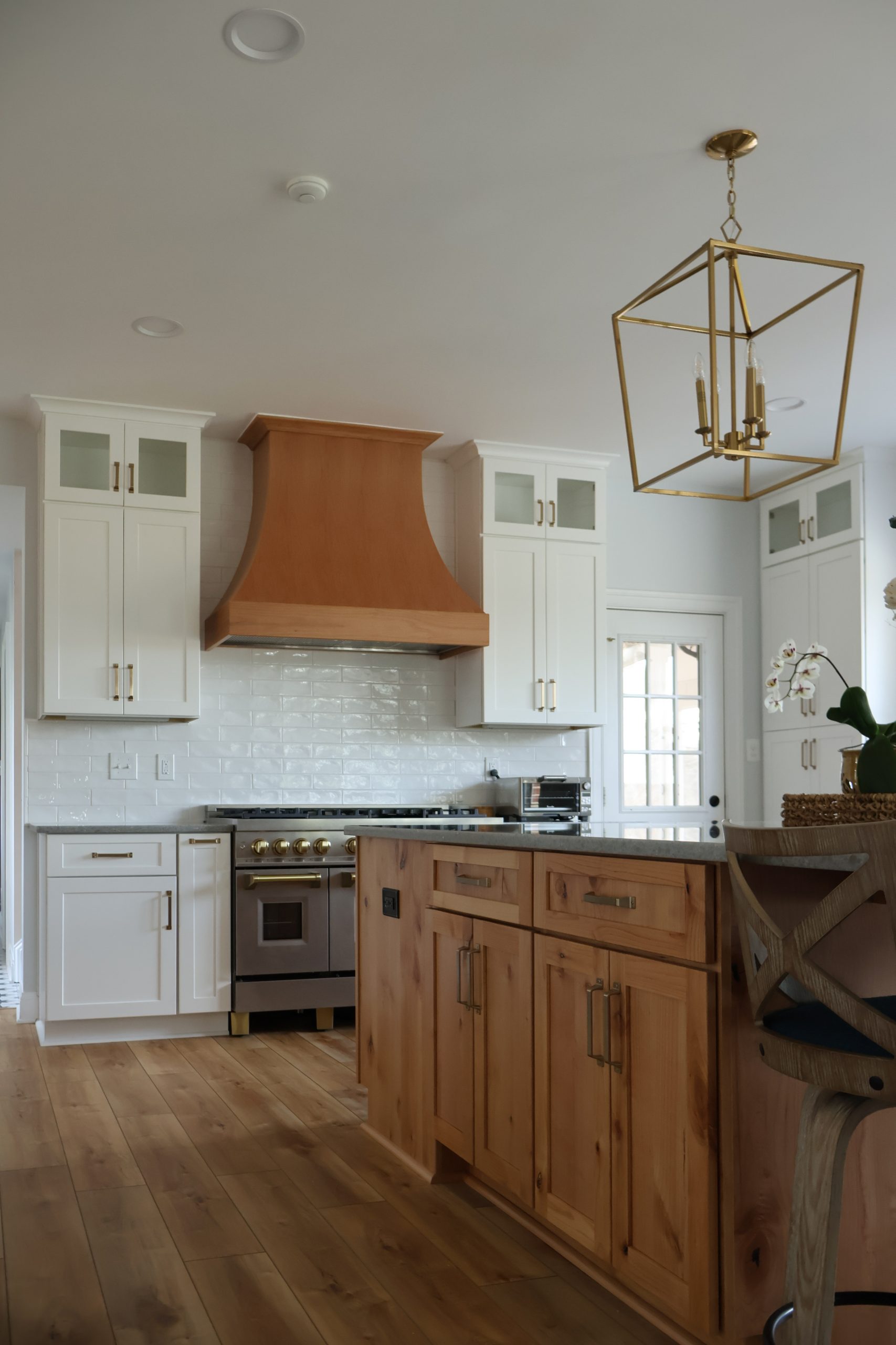 Modern kitchen with an organically curved range hood, soft lines, and warm natural finishes