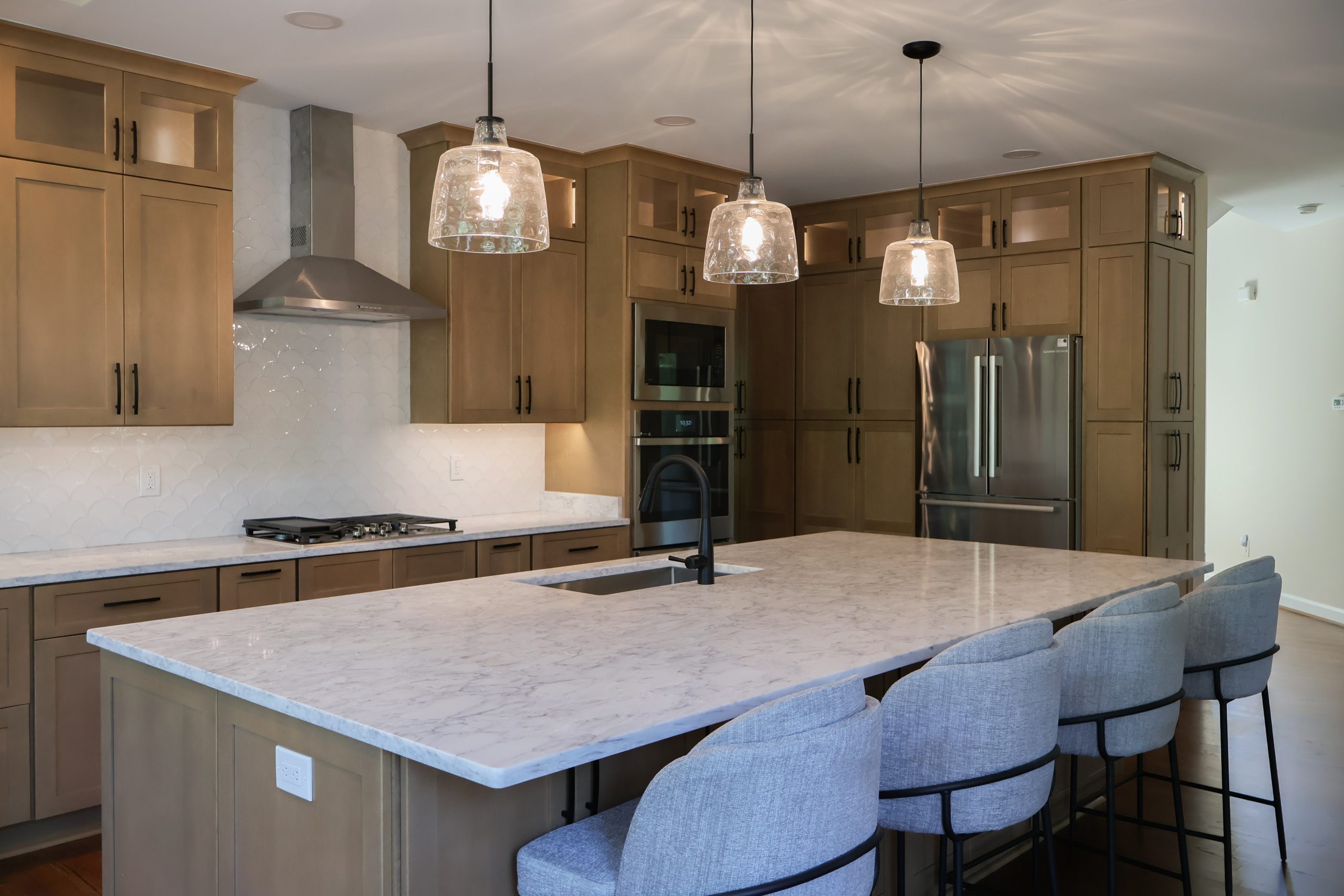 Kitchen with warm wood cabinets and a white countertop featuring natural gray veining