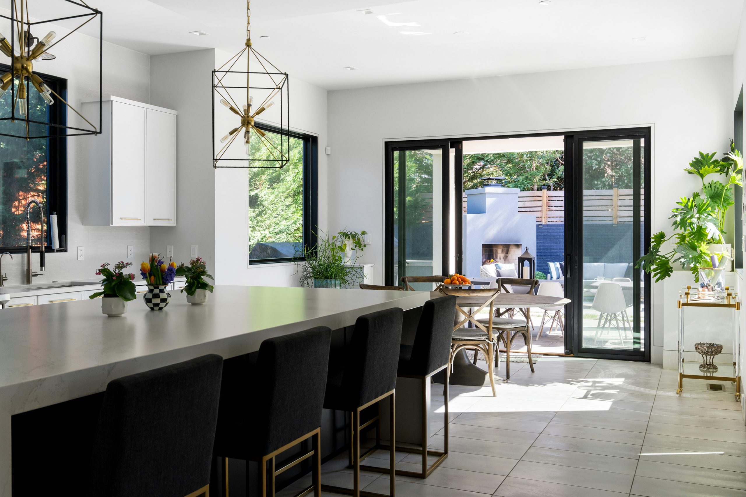 Modern open kitchen with black cabinets, natural light, and an island