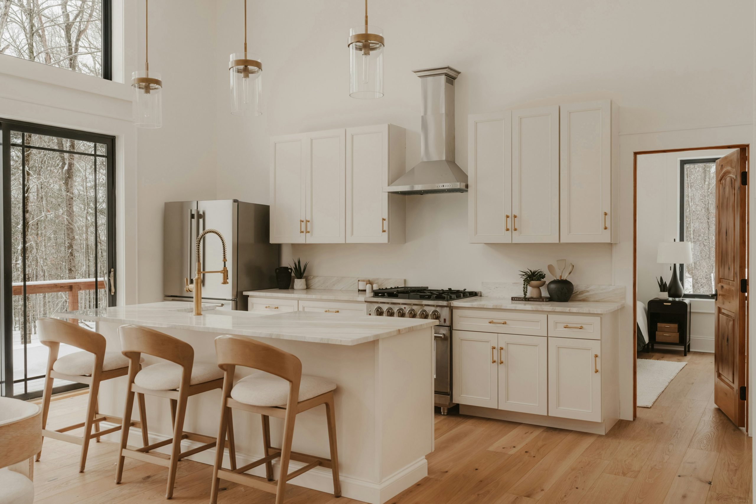 Bright open-concept kitchen with white cabinets, wood accents, and island seating