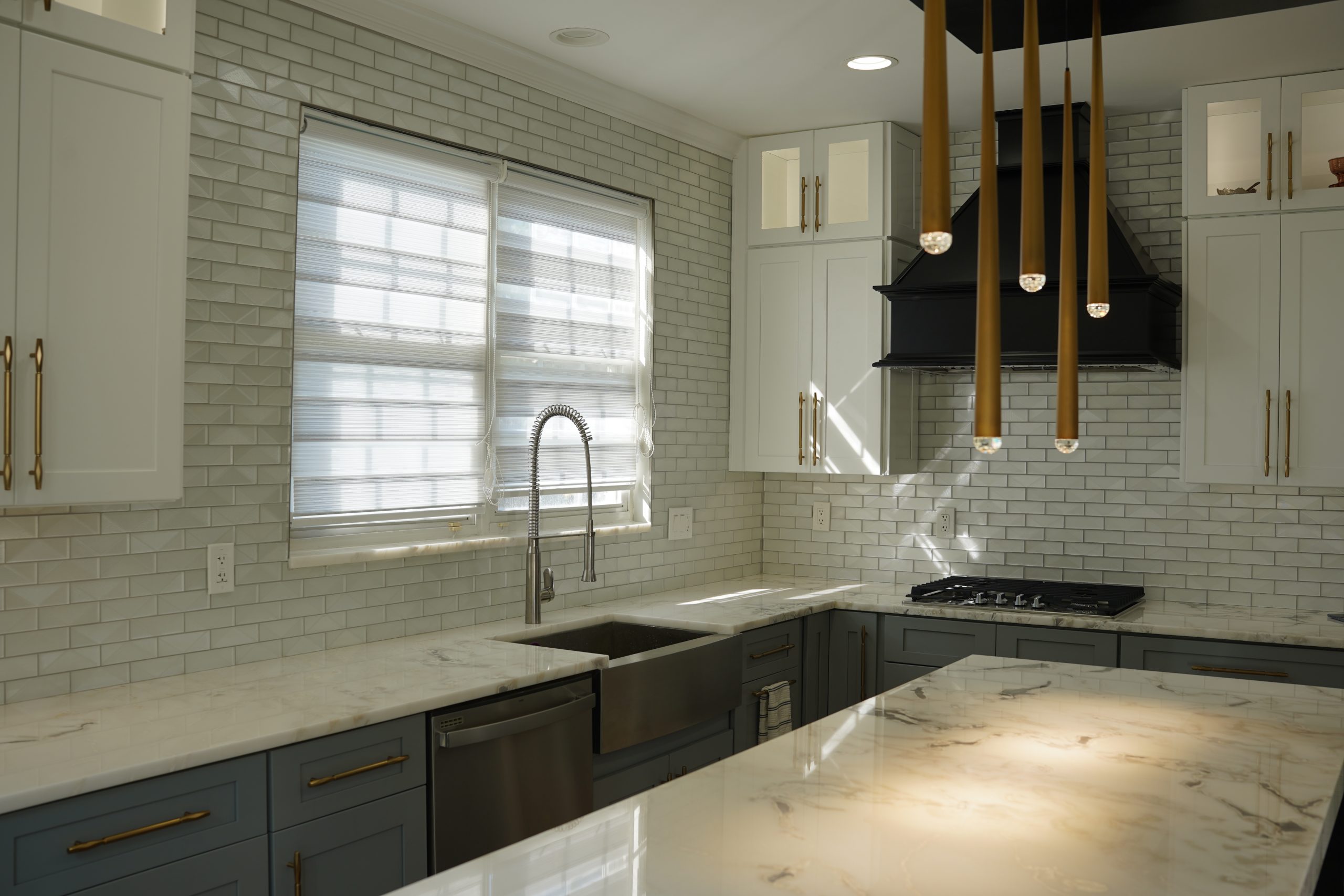 Updated kitchen with dark cabinets, white countertops, and large windows