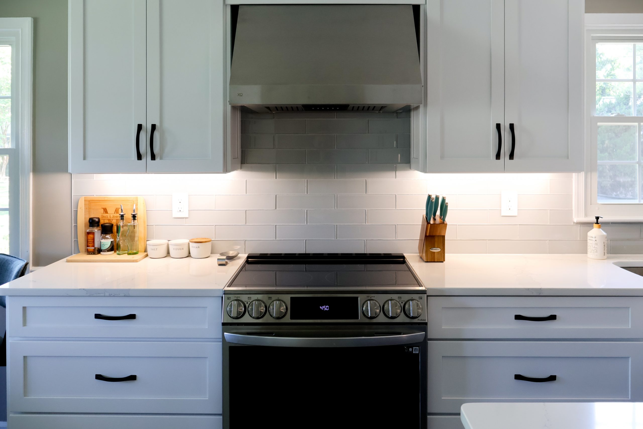 Bright kitchen with white cabinets, quartz countertops, and stainless steel appliances