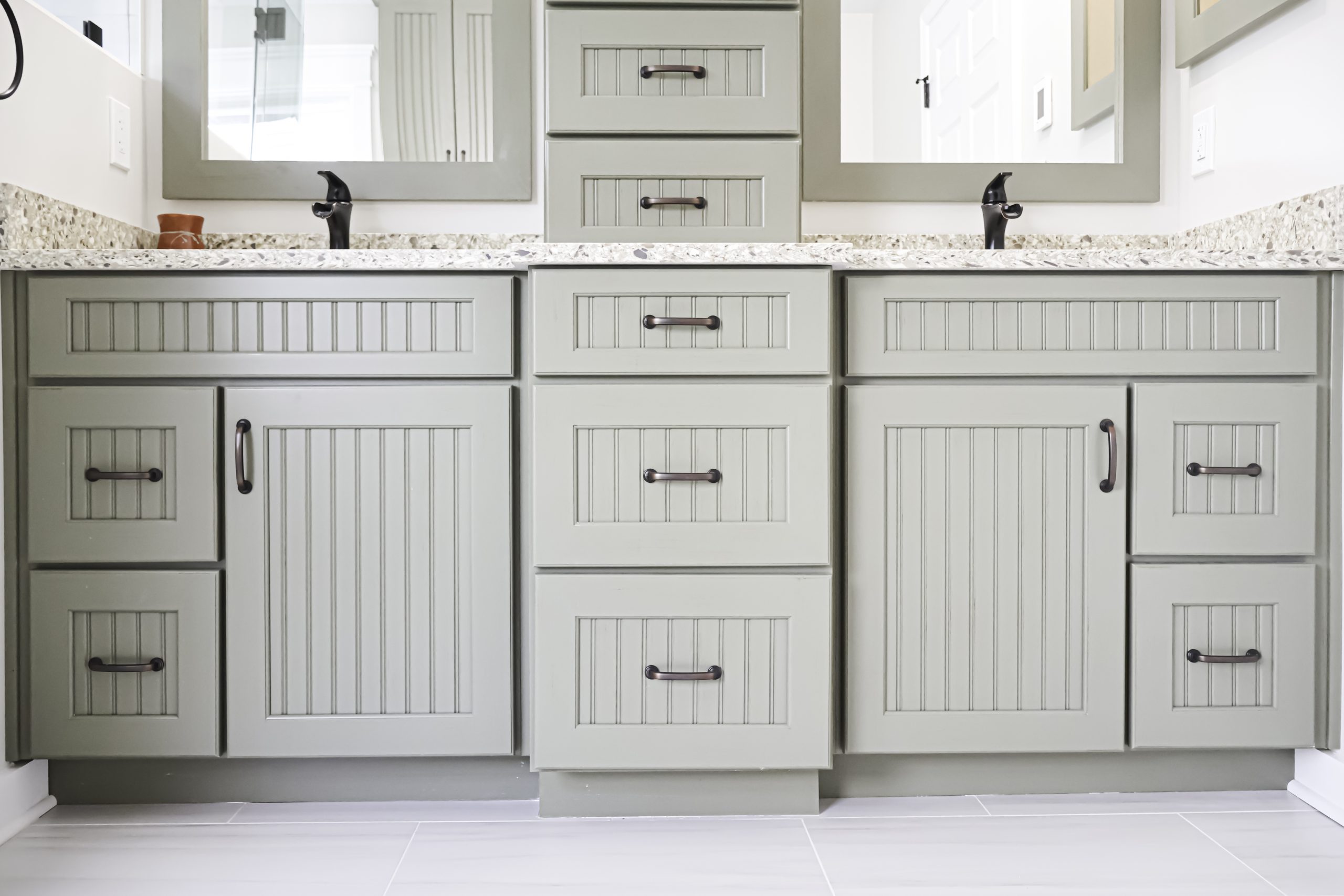Light gray bathroom vanity with quartz countertop and wall mirrors