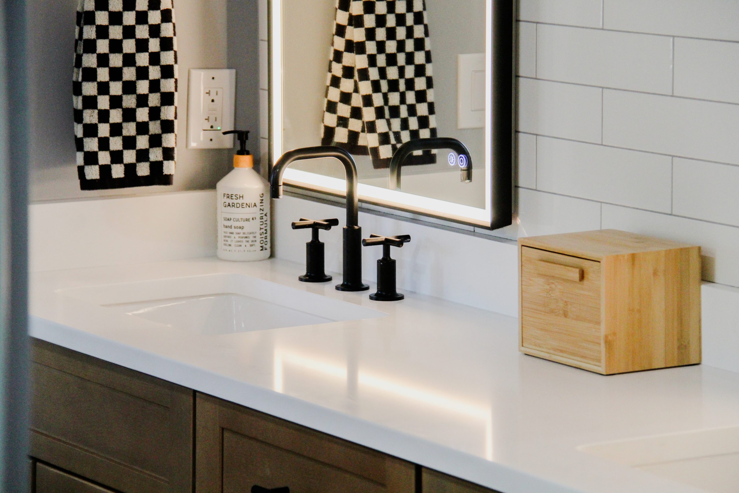 Modern bathroom vanity with white countertop and wall-mounted mirror