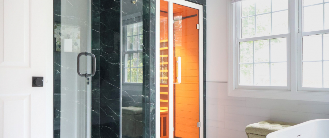 Remodeled bathroom in Great Falls, VA featuring a black marble walk-in shower with gold fixtures and an adjacent built-in infrared sauna.